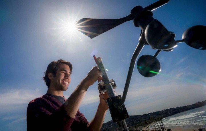 A graduate student checks a weather monitoring station at the Scripps Institution of Oceanography in UC San Diego