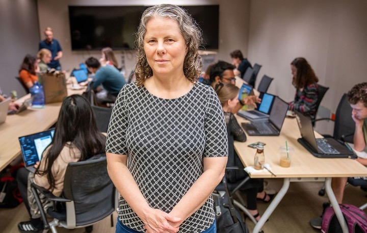 Pamela Cosman, a faculty member from Jacobs School of Engineering and director of the NeuroDiversity in Tech internship program at Qualcomm Institute, stands in the middle of a classroom surrounded by seated students focusing on their laptops